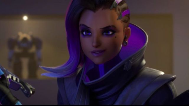Sombra holding her gun and smiling