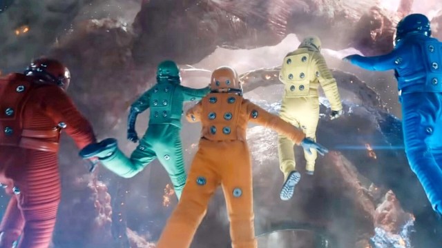 The guardians of the galaxy dressed up in multiple colored space suits seen from behind