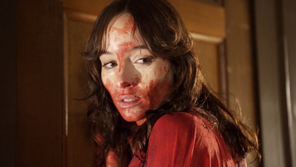 A young woman with blood and sweat all over her face.