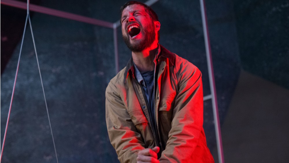 A man screaming under red lighting.
