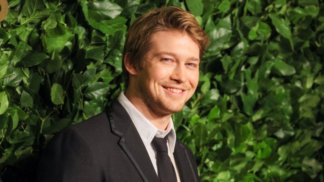 Joe Alwyn has a pleasant smile on his face which hides the deepest, darkest secrets in his heart