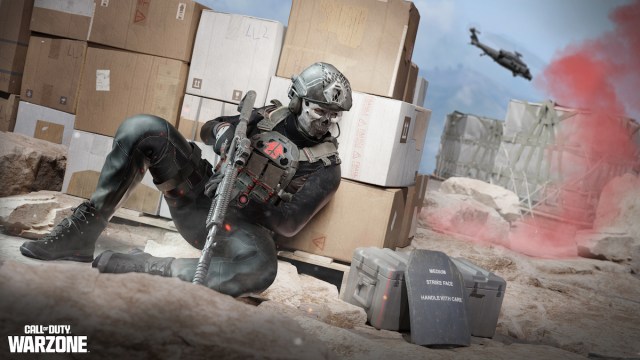 A soldier hidden behind cardboard boxes in Warzone.