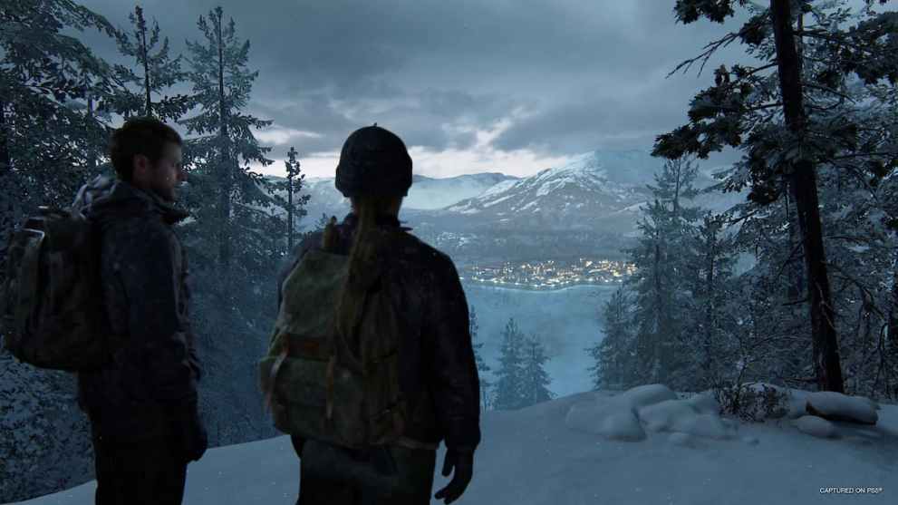 The Last of Us Part 2 characters Abby and Owen overlook a snowy Jackson in Wyoming.