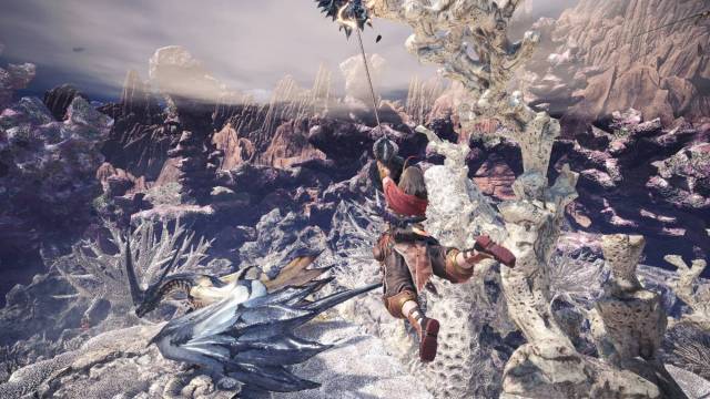 A character swinging on a cliff edge in Monster Hunter World.